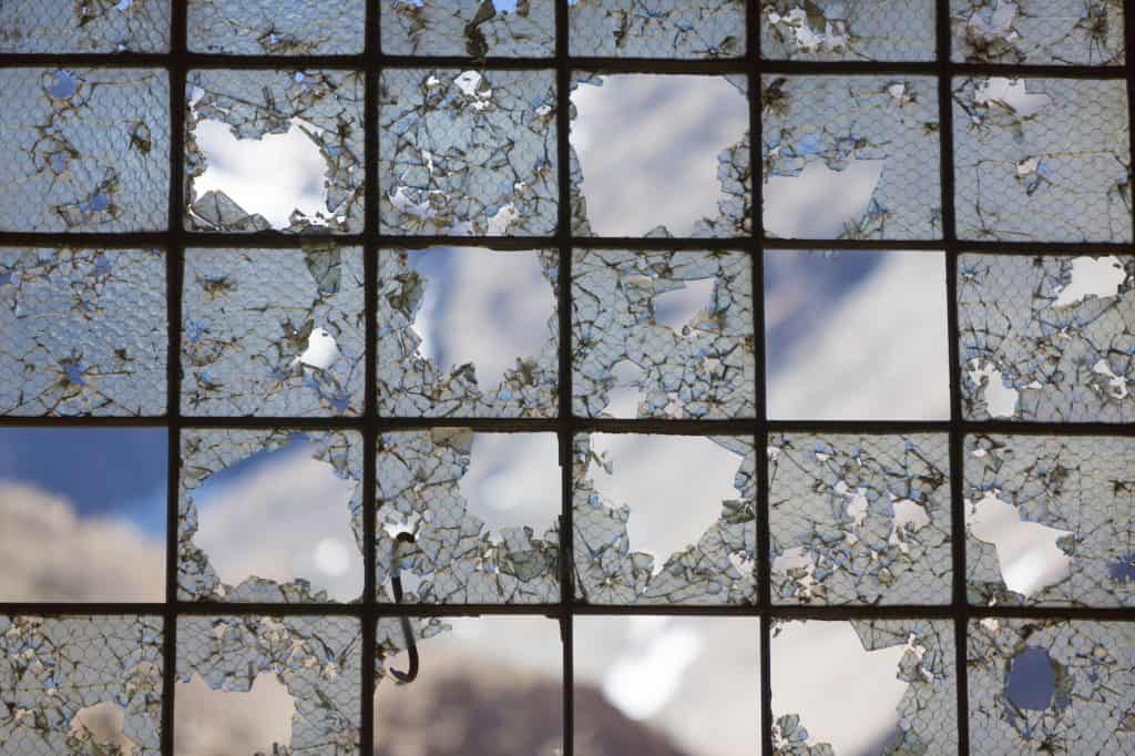 Old Industrial iron window frame rusting with broken glass.